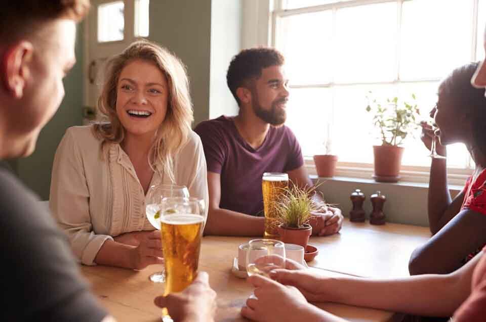 friends talking at a table in a pub