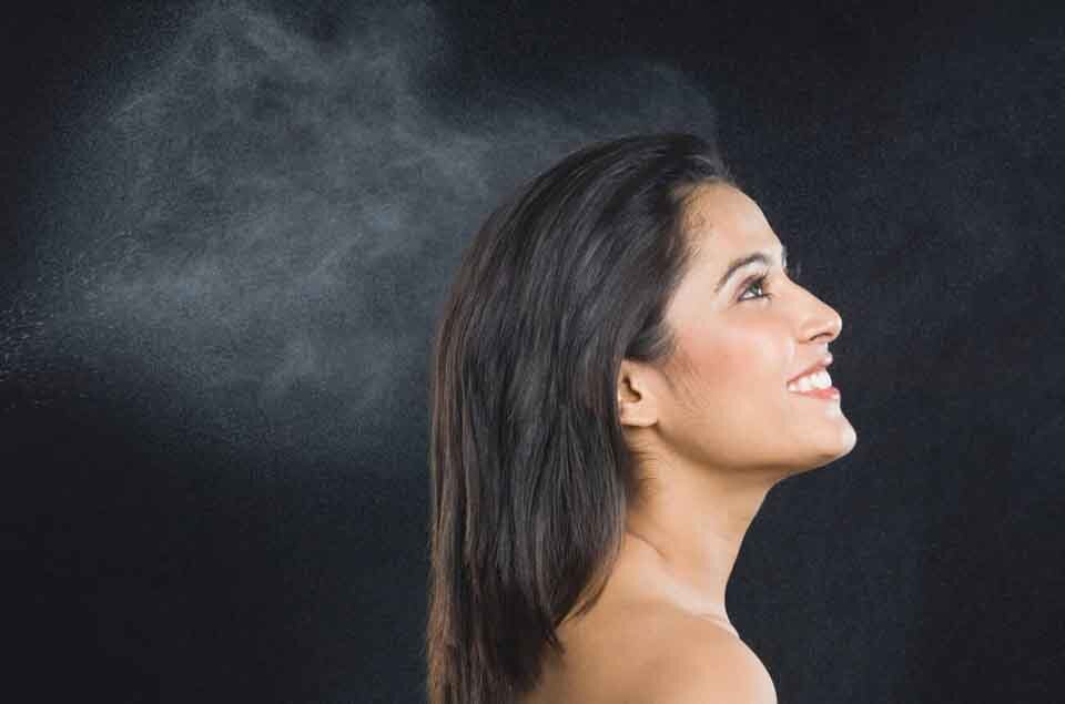 Woman applying fermented rice water to black hair